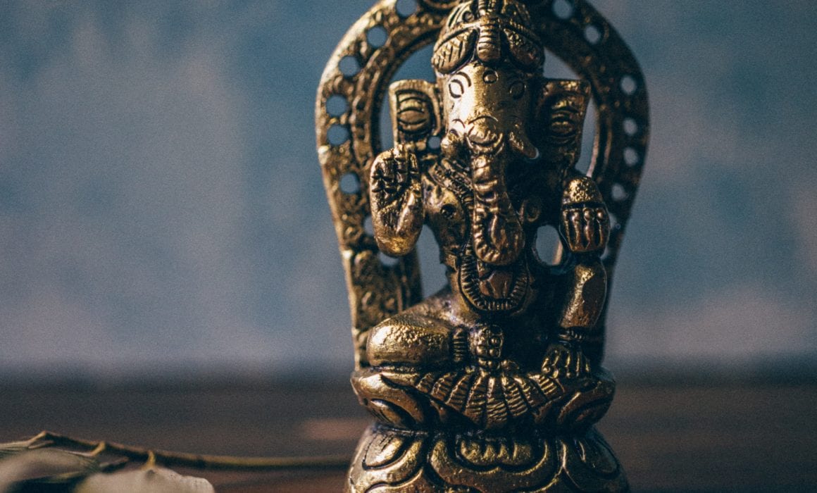 Ganesha Figurine On Brown Surface